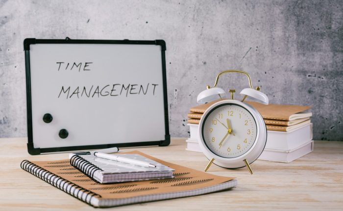 Alarm clock and books - time management and procrastination concept